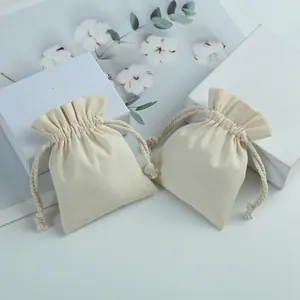 Detail view of eco-friendly cream cotton drawstring pouches for jewelry gift packaging