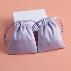 Detalle de dos bolsas de franela lavanda con cordón para joyas o lápiz de labios