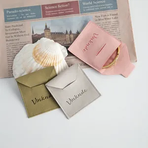 Detail view of premium microfiber envelope jewelry pouches in pink, olive green, and grey