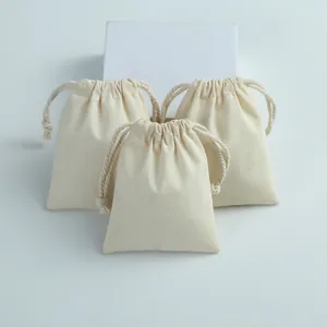 Trois pochettes en coton à cordon de serrage crème pour le rangement de bijoux.