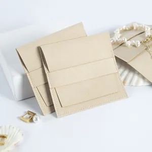Primer plano de bolsitas de microfibra para joyas en color beige con cierre de solapa