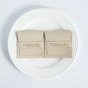 Detalle de bolsas para joyas de microfibra de ante con logotipo en un plato blanco.