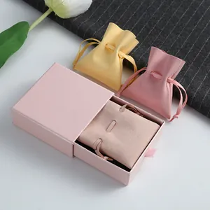 Detail view of pink and yellow microfiber jewelry pouches with matching gift box