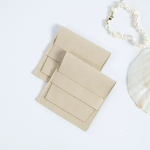 Vista detallada de bolsitas para joyas en ante de microfibra beige con cierre de solapa.