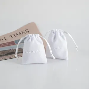 Dettaglio di due sacchetti per gioielli in peluche bianco con ricamo Vinknde.