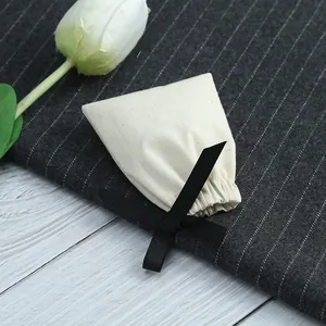 Gros plan d'un petit pochon en coton crème doté d'un nœud décoratif en ruban noir