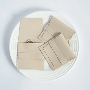 Primer plano de la textura de las bolsas de microfibra beige para joyas con solapa