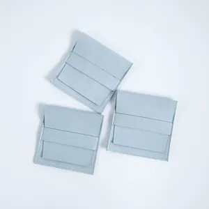 Vista detallada de bolsas para joyas de gamuza azul claro con solapa y tira