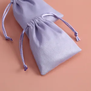Vista detallada de bolsas de franela morada con cordón para guardar joyas pequeñas
