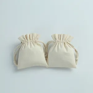 Detail showing two small cream cotton drawstring pouches for jewelry storage