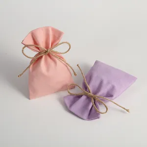 Close-up of pink and purple canvas drawstring pouches with jute twine bows