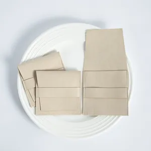 Detalle de bolsas de microfibra beige para joyas con solapa y correa sobre un plato