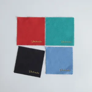 Close-up detail of four colorful microfiber cleaning cloths featuring embossed gold logo