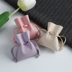 Detailed view of soft microfiber drawstring jewelry pouches in pink, purple, and beige