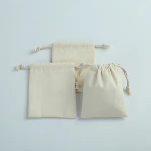Détail de trois petits sacs en toile de coton naturel avec cordon pour bijoux