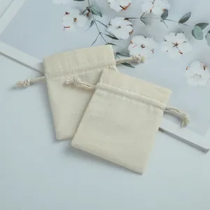 Macro view of small natural cotton drawstring pouches for jewelry packaging and storage