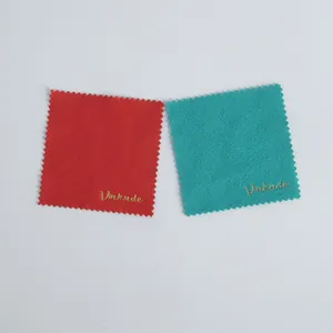 Macro view of red and teal microfiber jewelry cleaning cloths with zig-zag edges.