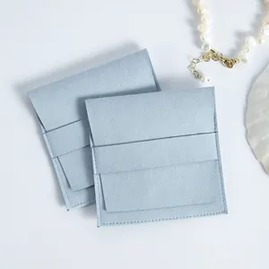 Detalle de bolsas de gamuza de microfibra azul claro para joyas con solapa.