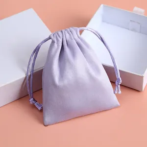 Elegante primer plano de una bolsa de franela púrpura para joyas con cajas de regalo