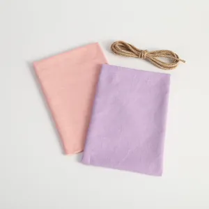 Detailed texture view of pink and purple linen drawstring pouches with jute twine