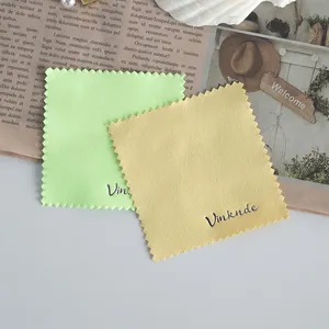 Detailed macro view of microfiber cleaning cloths with zigzag edges and logo embroidery