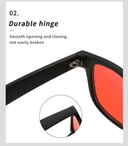 Close-up of durable metal hinge on black frame sunglasses with red lenses.