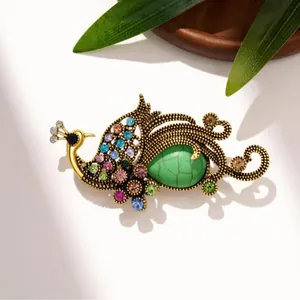 Vintage elegant peacock brooch with colorful rhinestones and green stone on gold base