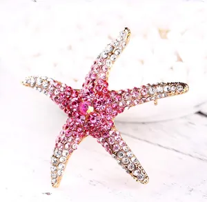 Primer plano de un broche de estrella de mar vintage con cristales en degradado rosa
