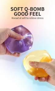 Close-up of translucent purple and yellow squishy toys being kneaded by hand for stress relief