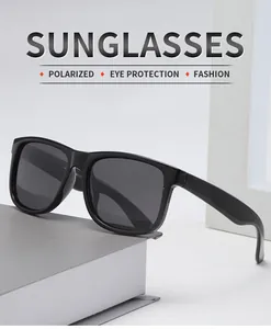 Detailed side view of classic black polarized sunglasses on a gray book.