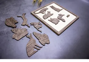 Gros plan de pieces de puzzle en bois en forme de chat avec grain naturel sur fond gris.