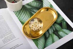 Detailed macro view of a floral crystal ball on a golden metal display tray