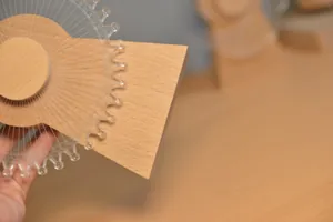 Primer plano de base de madera y pieza de noria acrílica para caja de música 3D