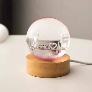 Detail of crystal ball night light with LOVE engraving and wooden base