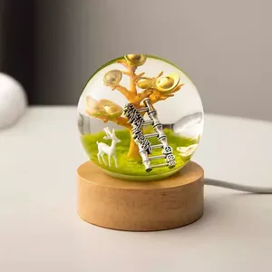 Macro view of creative resin crystal ball night light with golden tree and deer