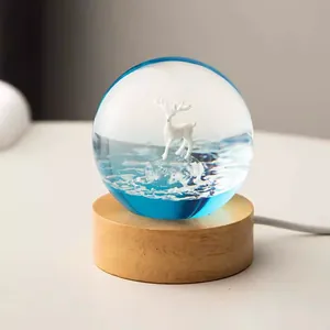 Detailed close-up of a crystal ball night light featuring a white deer on a wooden base