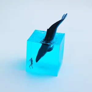 Macro view of blue resin cube ocean whale night light featuring a small diver figure