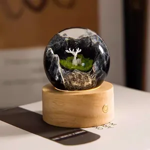 Close-up of a creative resin crystal ball night light featuring a white deer on wooden base