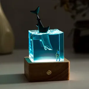 Detailed shot of a shark and diver resin night light with glowing wooden base