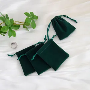 Detalle de elegantes bolsas de terciopelo verde esmeralda con cordón para joyería