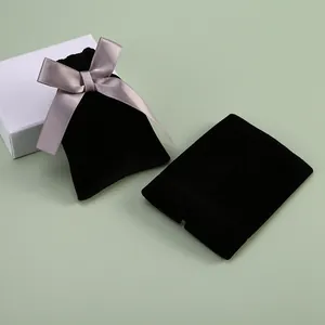 Détail de pochettes à bijoux en velours noir avec un élégant nœud en satin gris