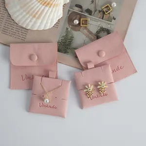 Detail of pink microfiber jewelry pouches with snap buttons and custom embroidery logo