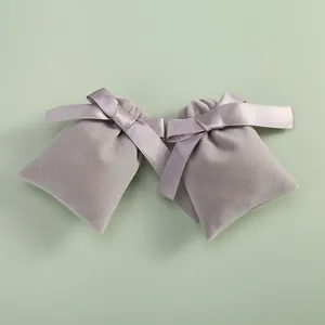 Detailed view of elegant grey velvet jewelry pouches featuring silk ribbon bow closures.
