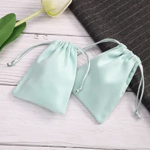 Detalle de dos bolsas de terciopelo verde menta con cordón para joyas