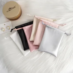 Close-up of assorted PU leather drawstring pouches for jewelry on white fur background