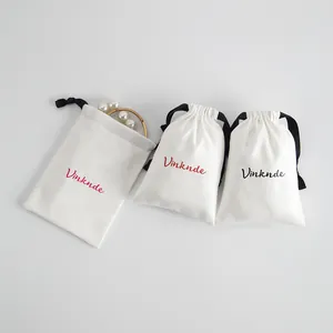 Vista detallada de bolsas de algodón blanco con cordón para joyas con logo