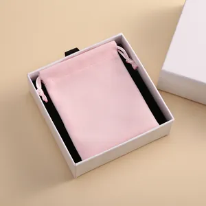 Rosa Samt-Beutel mit Kordelzug in einer weißen Geschenkschachtel mit schwarzem Inlay