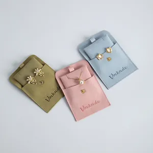Detailed view of velvet jewelry pouches with snap buttons in pink, blue, and khaki colors.