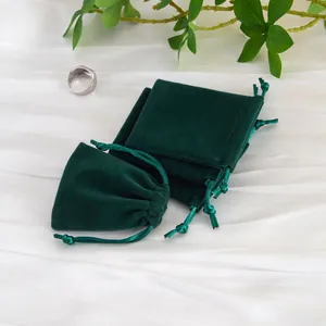 Vista detallada de bolsas de joyería de terciopelo verde oscuro y bolsas con cordón