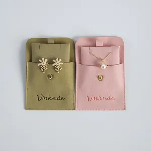 Detailed view of flap snap velvet jewelry pouches in olive green and pink colors.